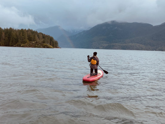 A single person paddleboarding on Pitt Lake, BC.